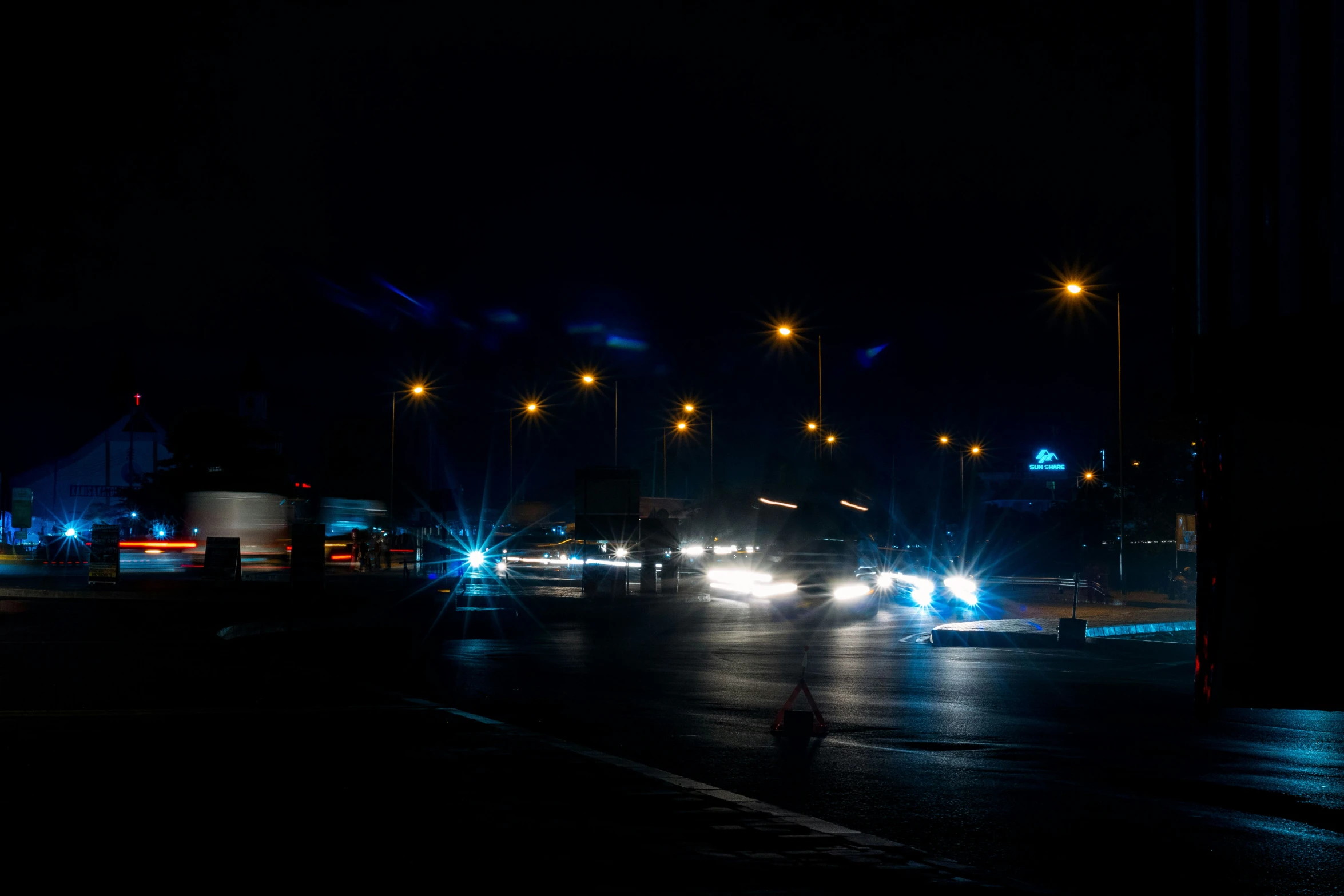 a city street with lights at night with traffic