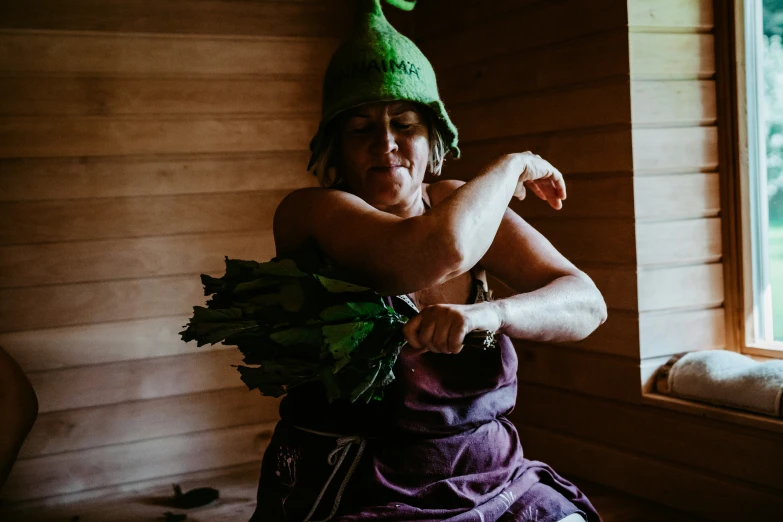 a woman in a green hat holding a carrot