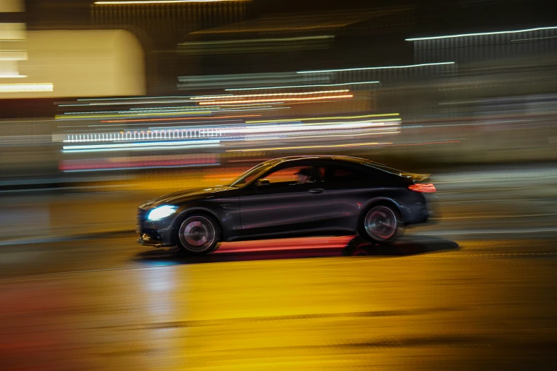 a car traveling down a road in the rain at night