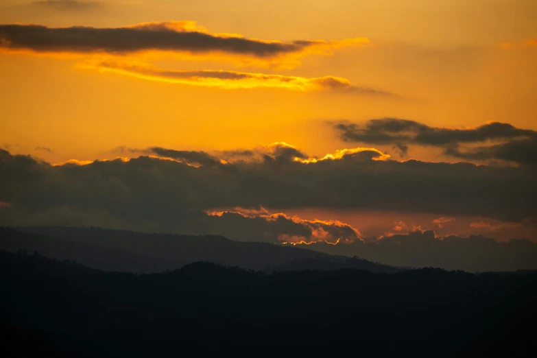 a plane flying by during sunset over the hills