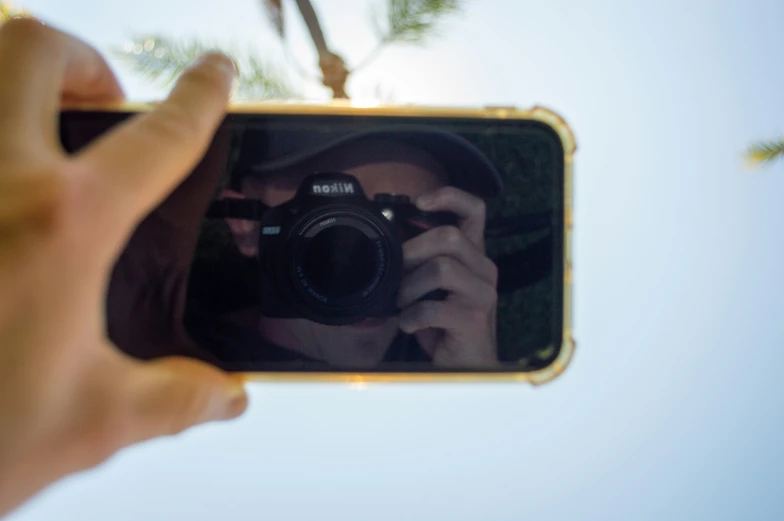 a hand taking a pograph of someone with a cellphone