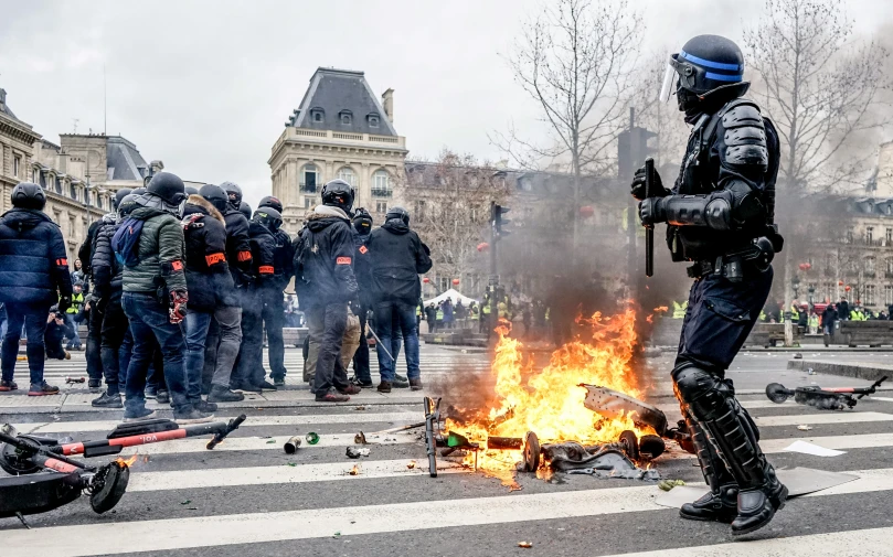 a man on fire with a police uniform holding a weapon