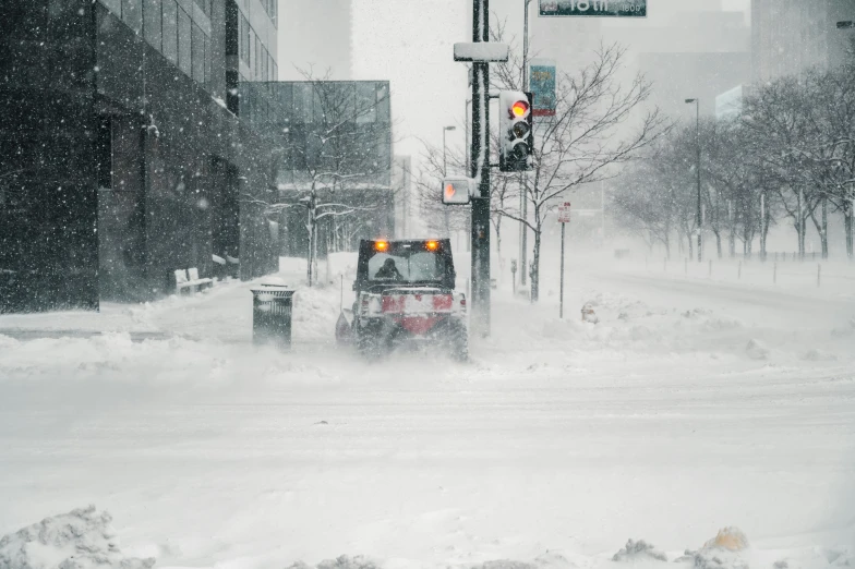 a snow plow clearing a street on a snowy day