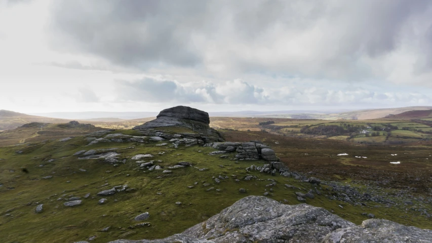 a stone cliff on the side of a grassy hill