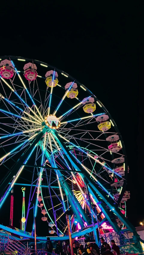 a large ferris wheel sitting in the dark next to a clock