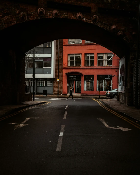 an archway in the middle of a road that shows people in the distance