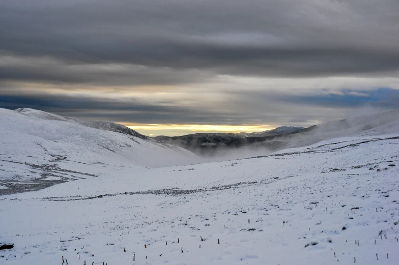 a person walking across a snow covered hill