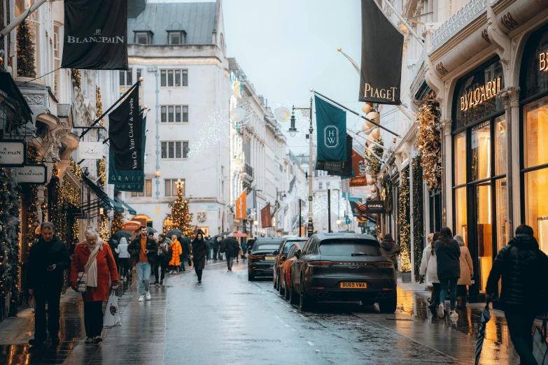 pedestrians walk down a sidewalk covered in lights