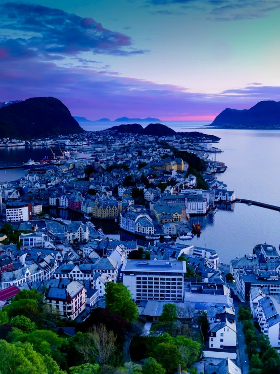 an aerial view of a city with water and mountains