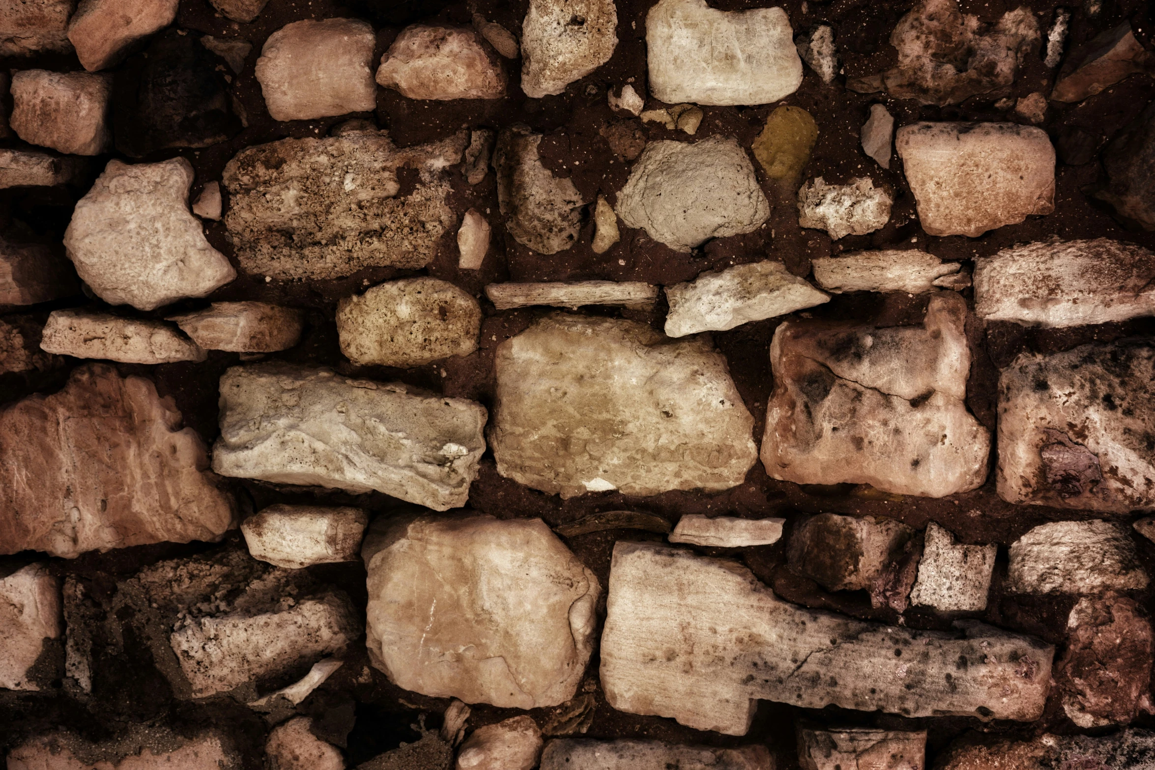 a wall made from many rocks and cement blocks