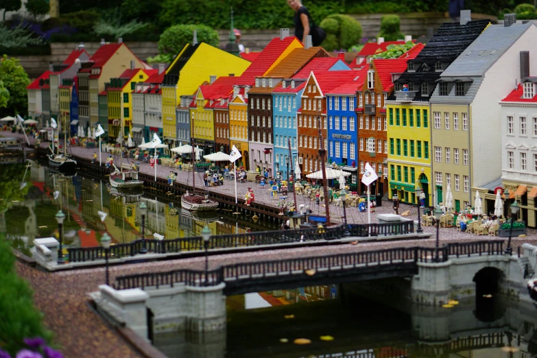 many tiny, colorful houses along the river are by a bridge