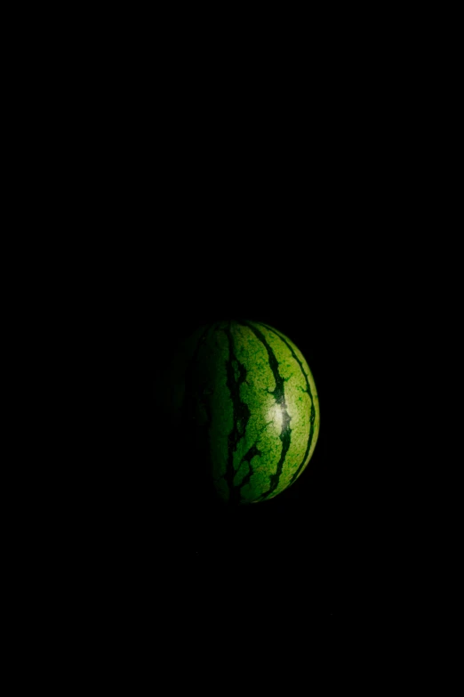 a closeup of a green watermelon in the dark