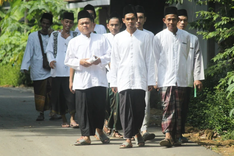 men are standing together in a line outside