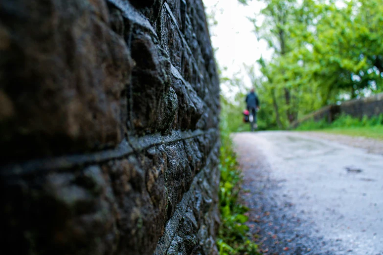 a brick wall sits near a road