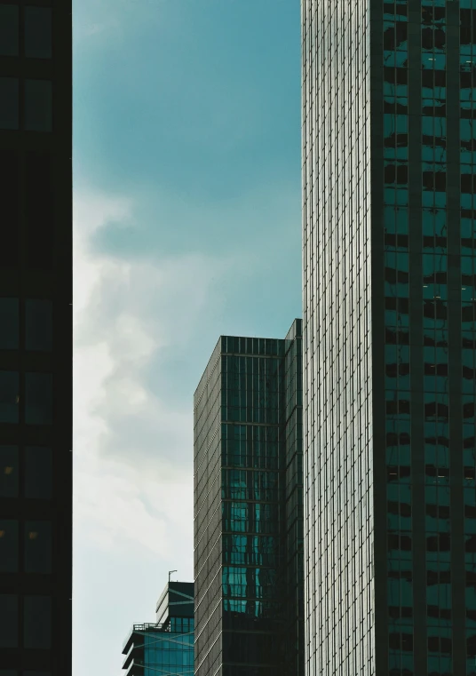 very tall skyscrs are shown with a cloudy sky in the background