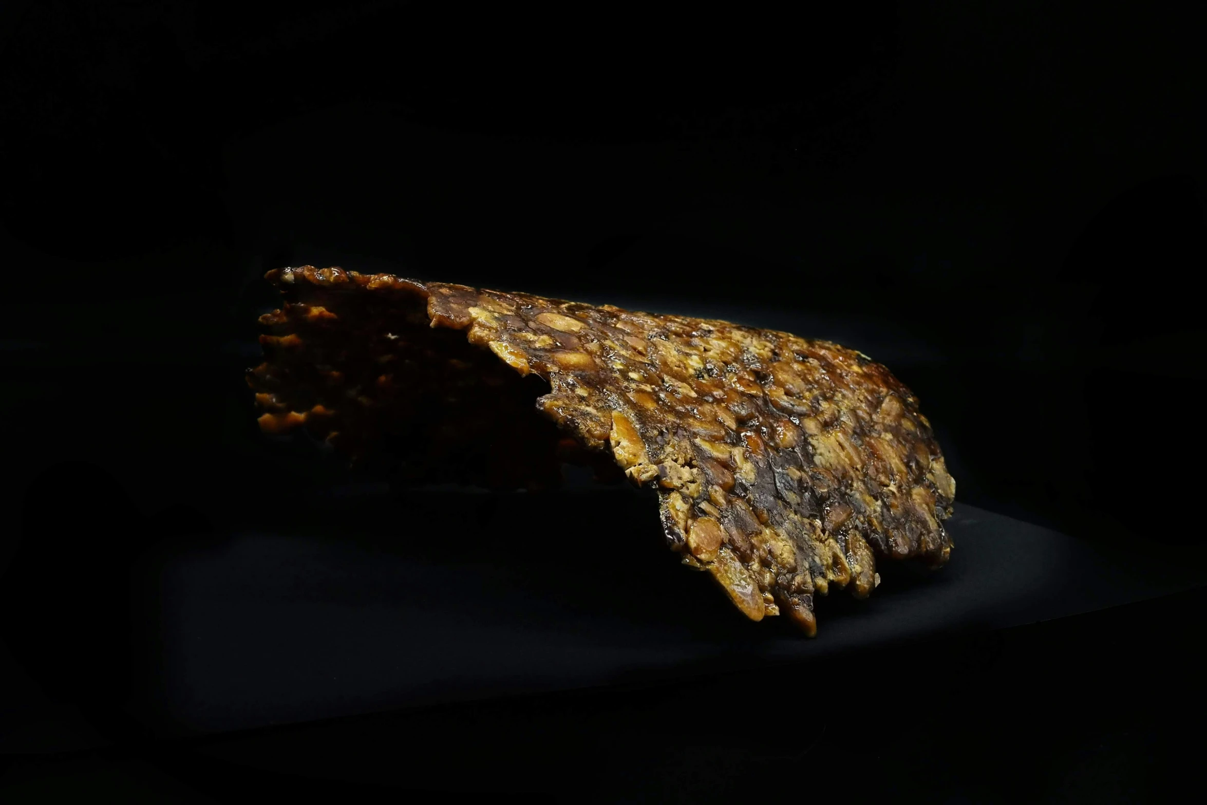 a piece of chocolate, orange and white food with black background