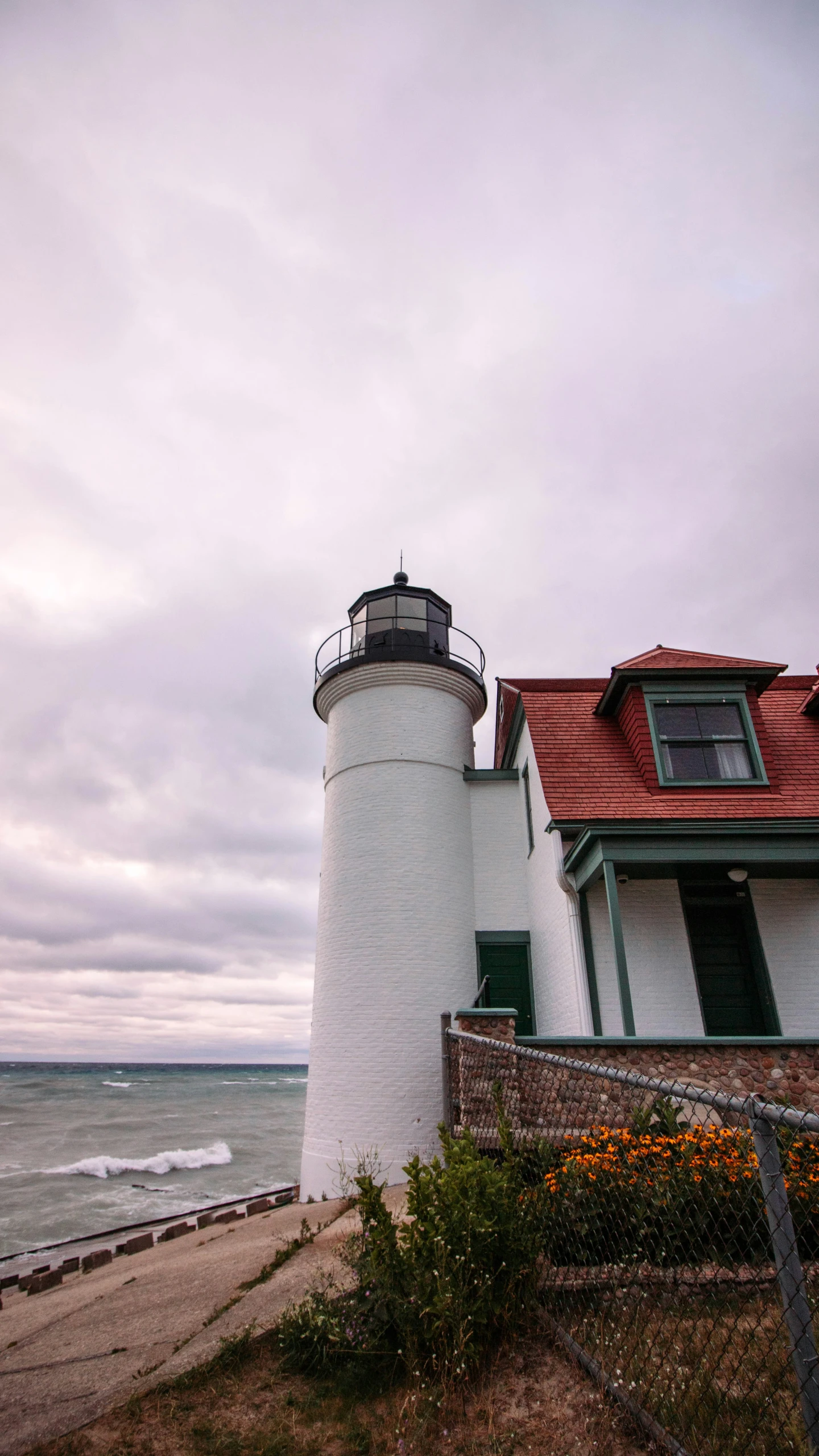 a lighthouse on the side of a road next to a beach