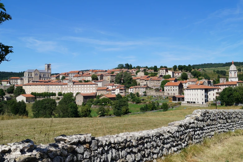 a village nestled on a hill surrounded by rock walls