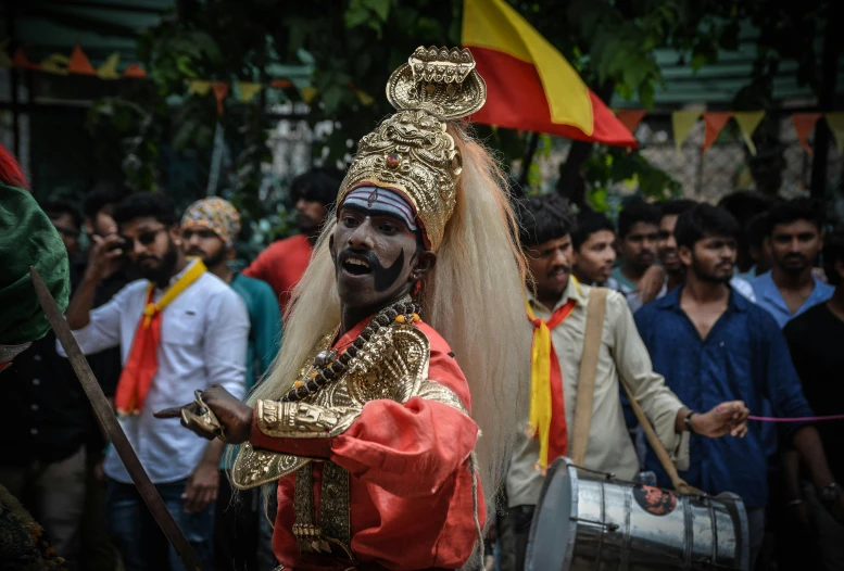 a man dressed in gold and with beard playing an instrument