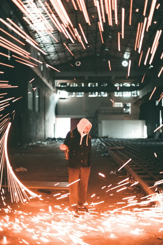 someone holding an umbrella stands in front of a lot of sparks