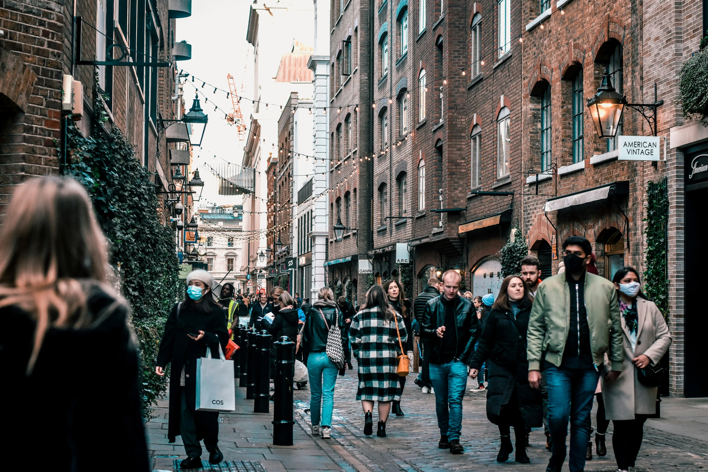 people are walking on a city street in the evening