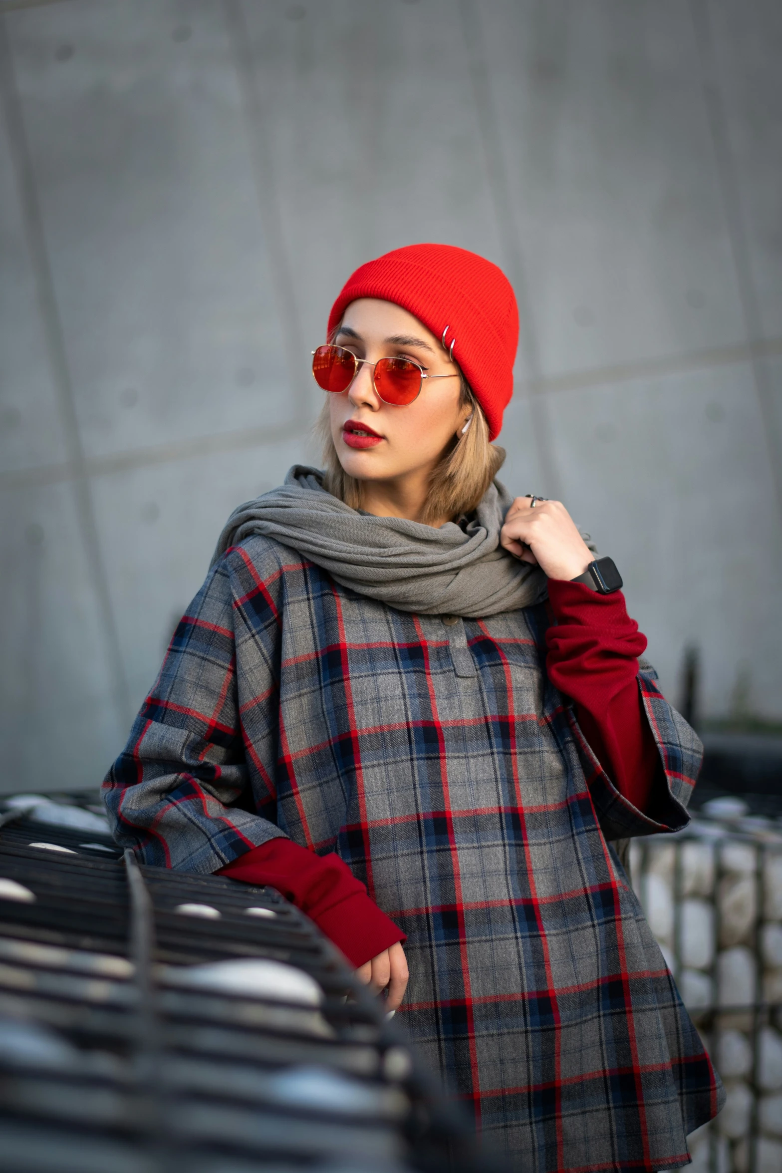 a woman standing next to a wall with a red hat and coat