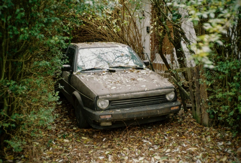 an old rusted out car in a wooded area