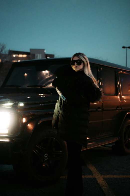 a woman wearing sunglasses standing next to a suv