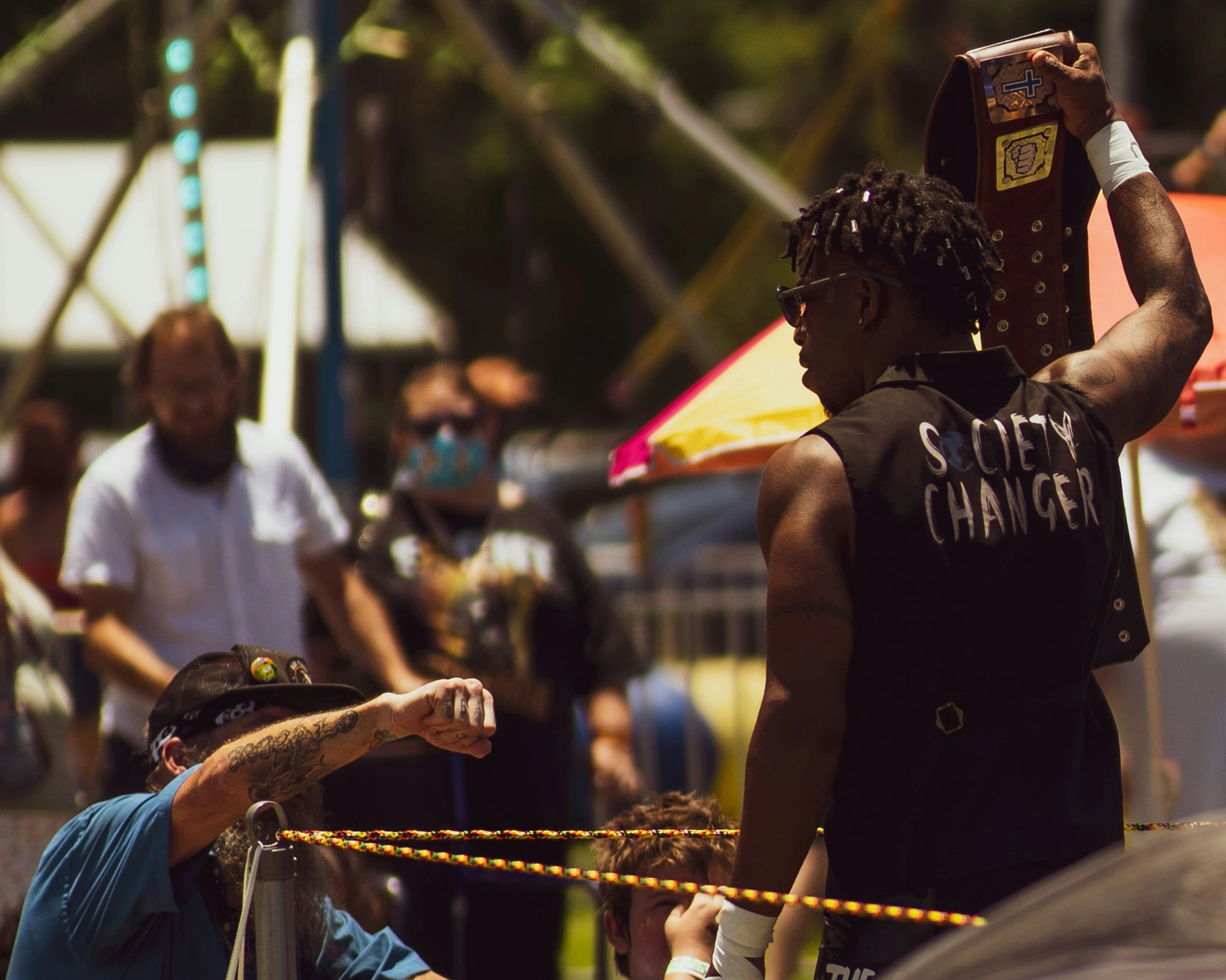 the man is walking by a crowd as he holds his arm around another man