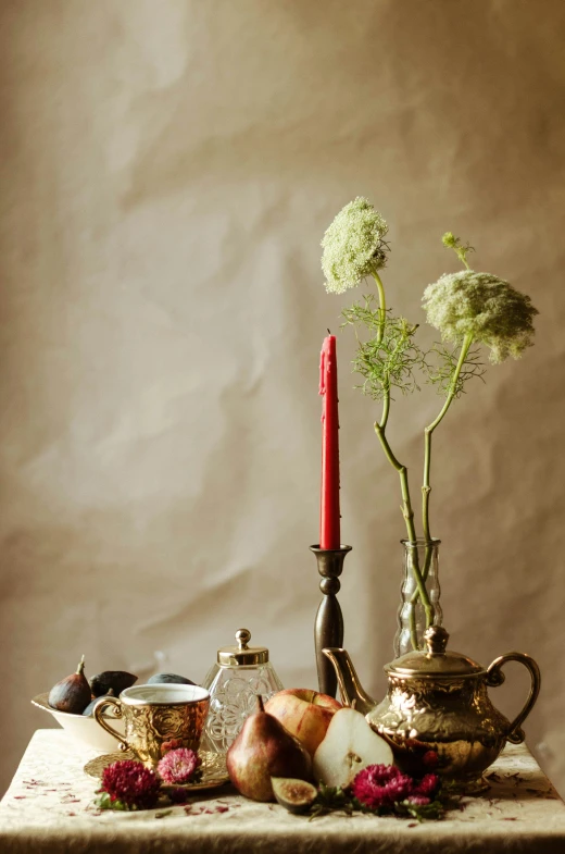 some candles a tea pot and some flowers