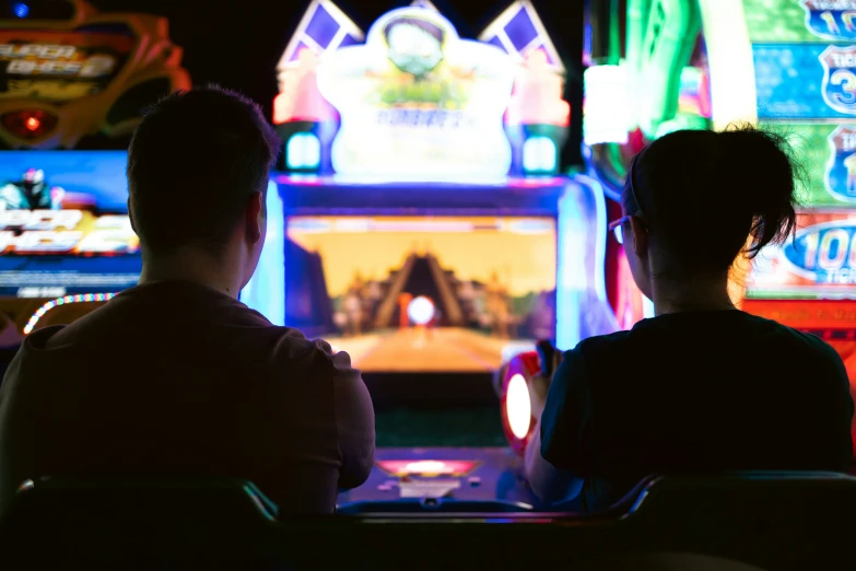 two people sitting in front of some big machines