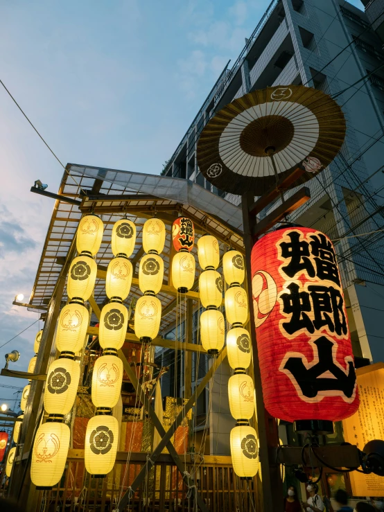 chinese lanterns and signs are hanging outside at dusk