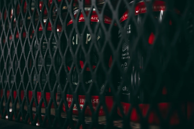 a bunch of fire hydrants sitting behind a black fence