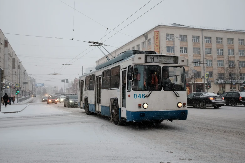 a city bus driving down the street in the snow