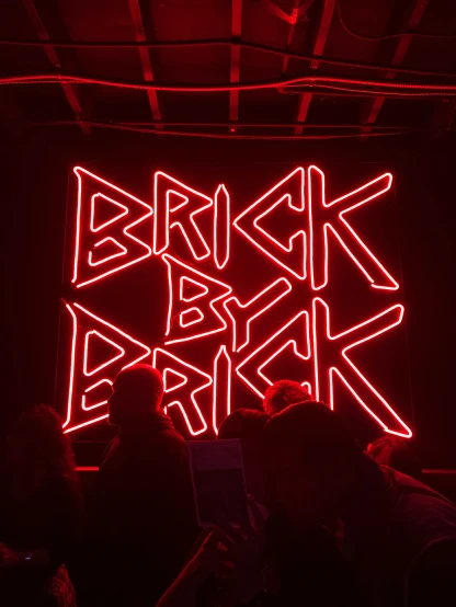 red neon sign with the words brick bar inside it