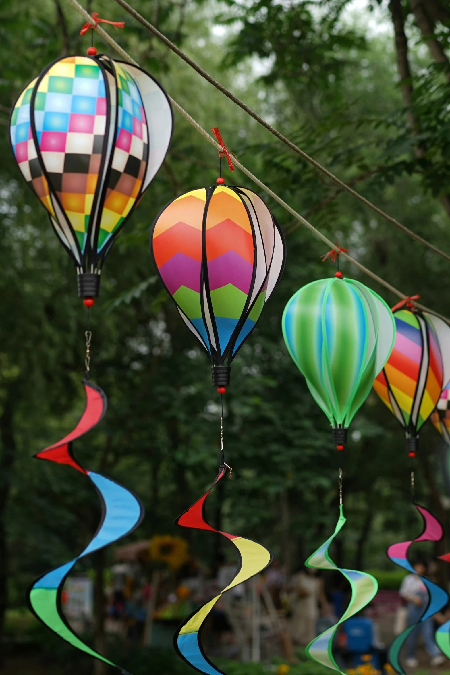 multiple air balloons that are hanging in the trees