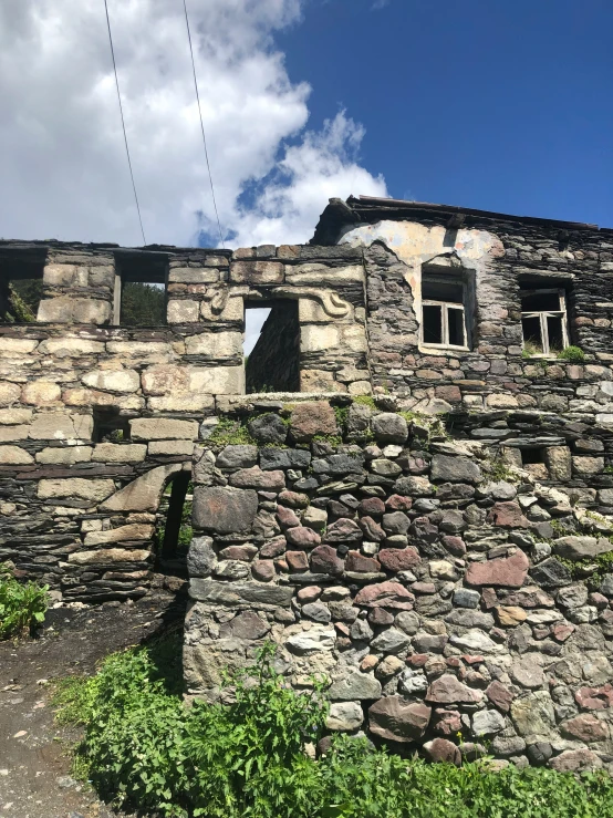 an old, very rustic stone building near a rock path