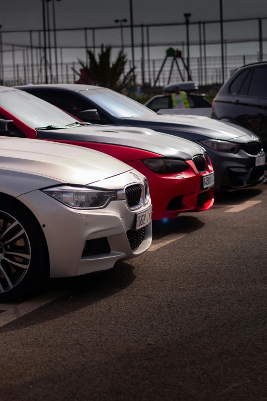 three bmw cars parked on the side of a road