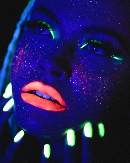 a woman in blue with a multi - colored light on her face
