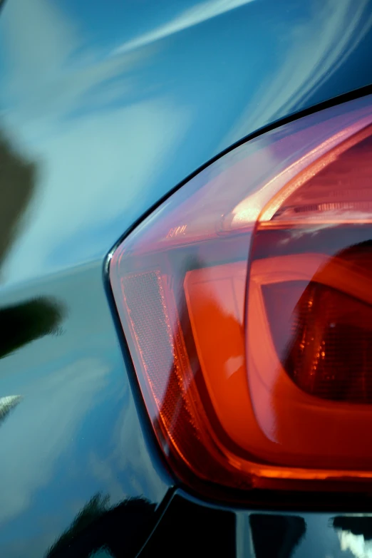 the rear of a blue vehicle with a red light