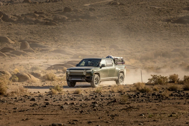 a gray pick up truck driving down a dirt road