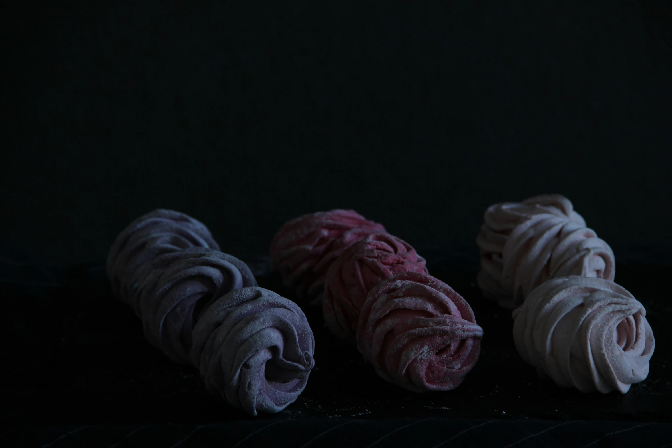 four different types of pastry on a black surface