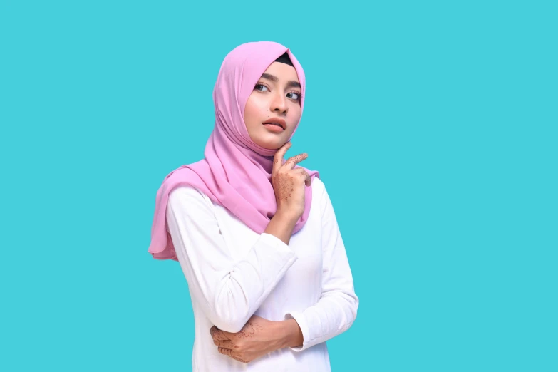 a woman in white wearing a pink hijab