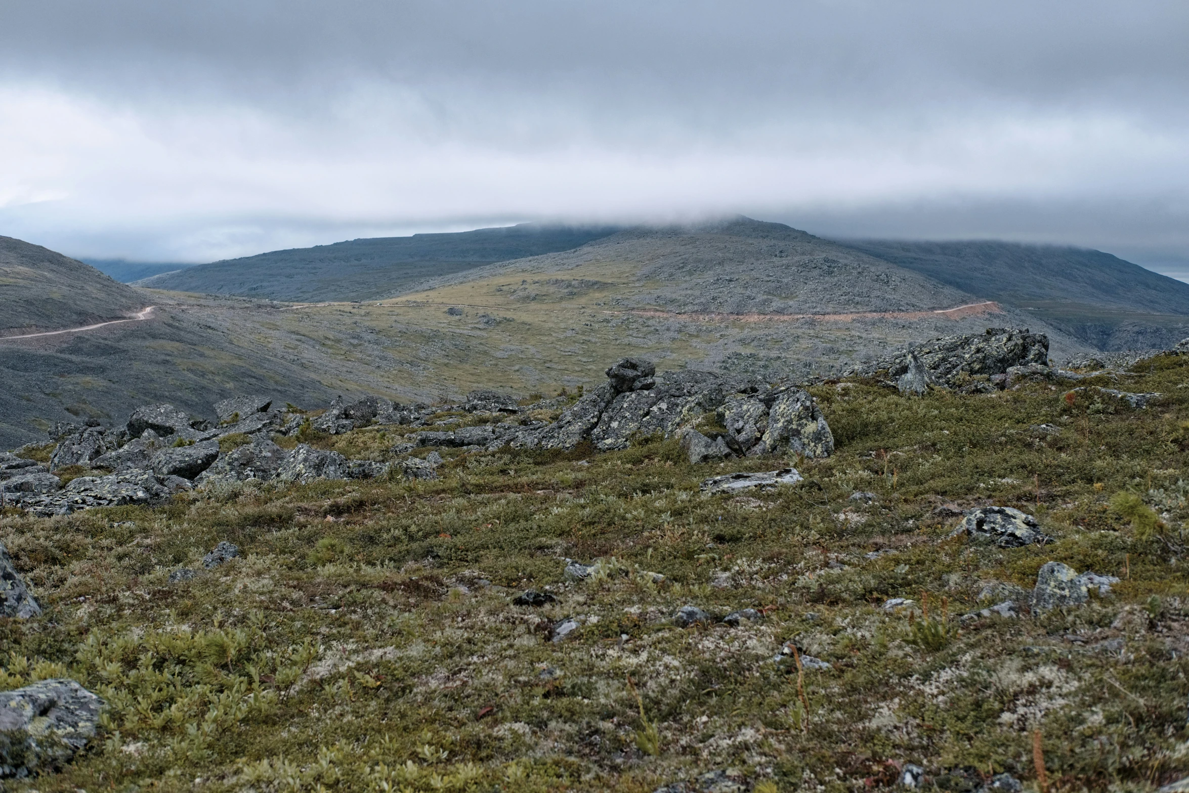 a view of some hills and fog in the distance