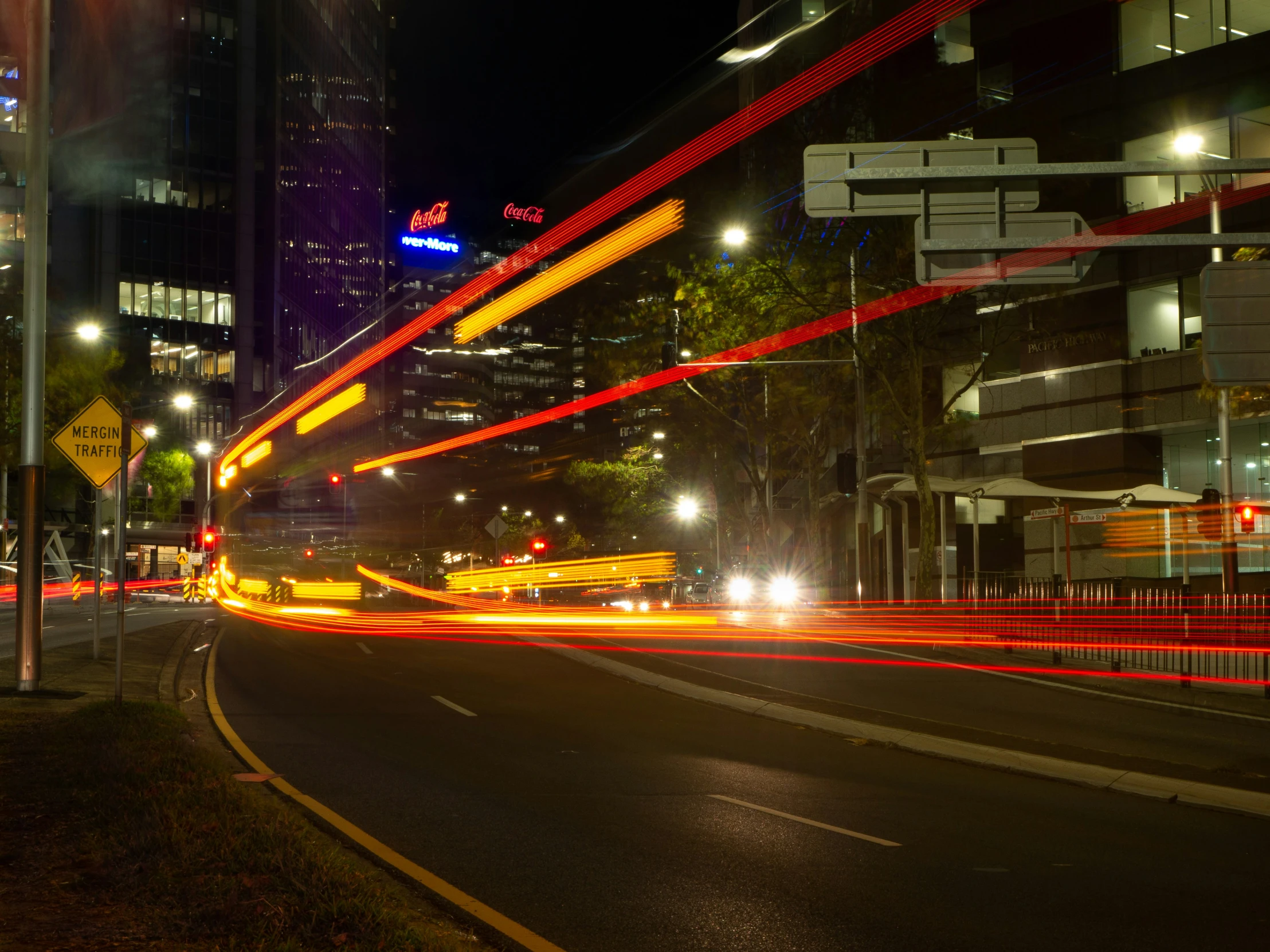 a dark city street with light streaks in the sky