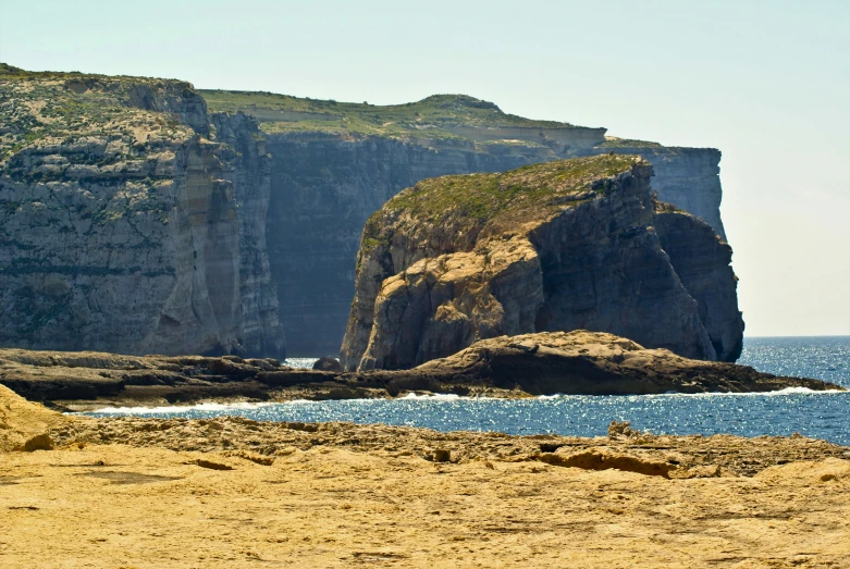 an area near water and mountains that have rocks