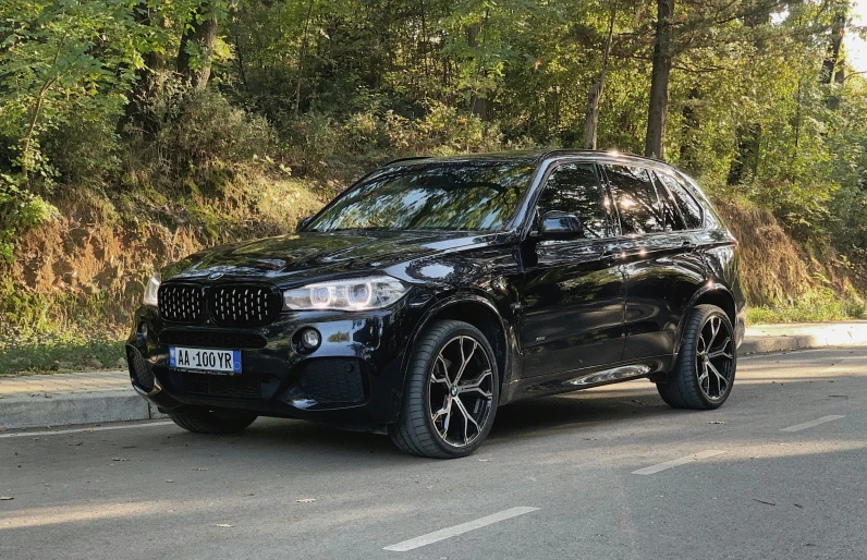 a black jeep parked on a forest road