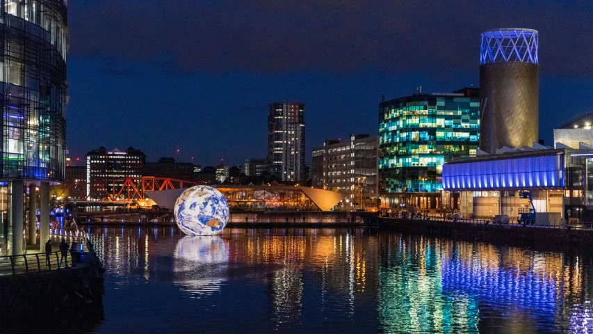 an urban setting with its lights reflecting off the water