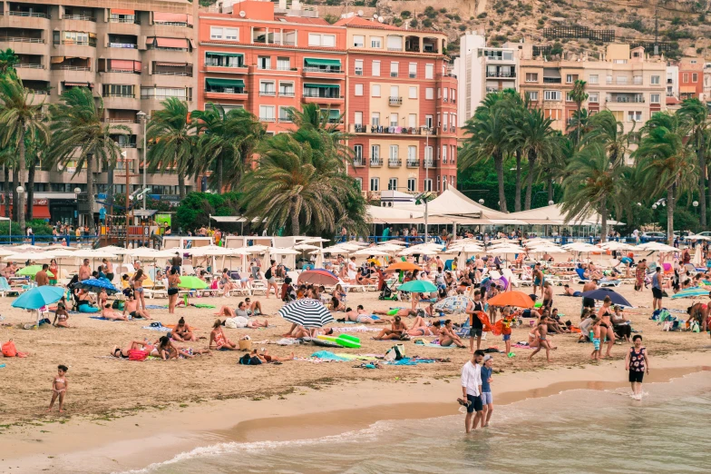 a bunch of people on the beach in the daytime