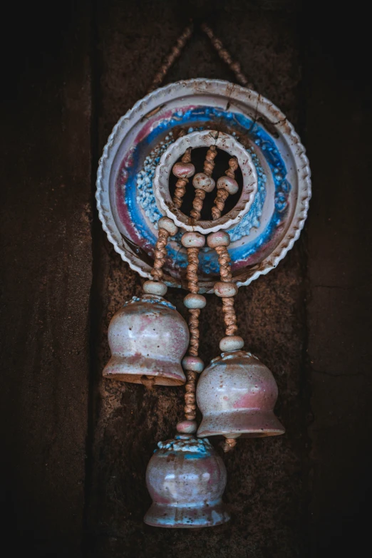 three different bell style objects hang in a room